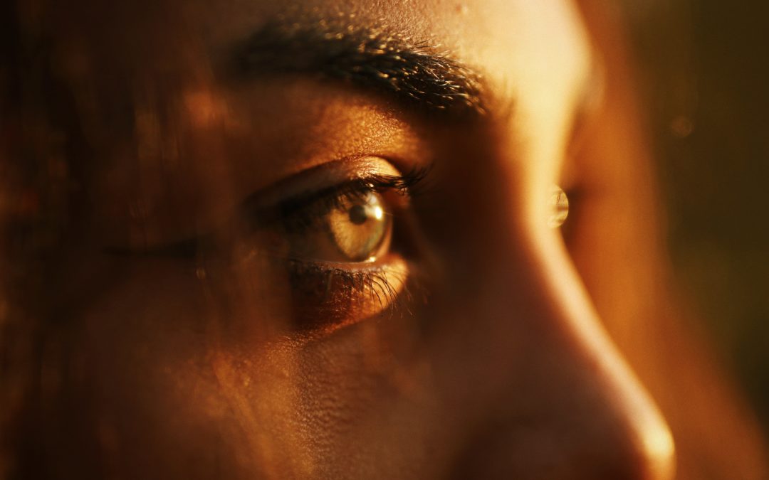 Image of sun shining on woman's face, close up of the eyes